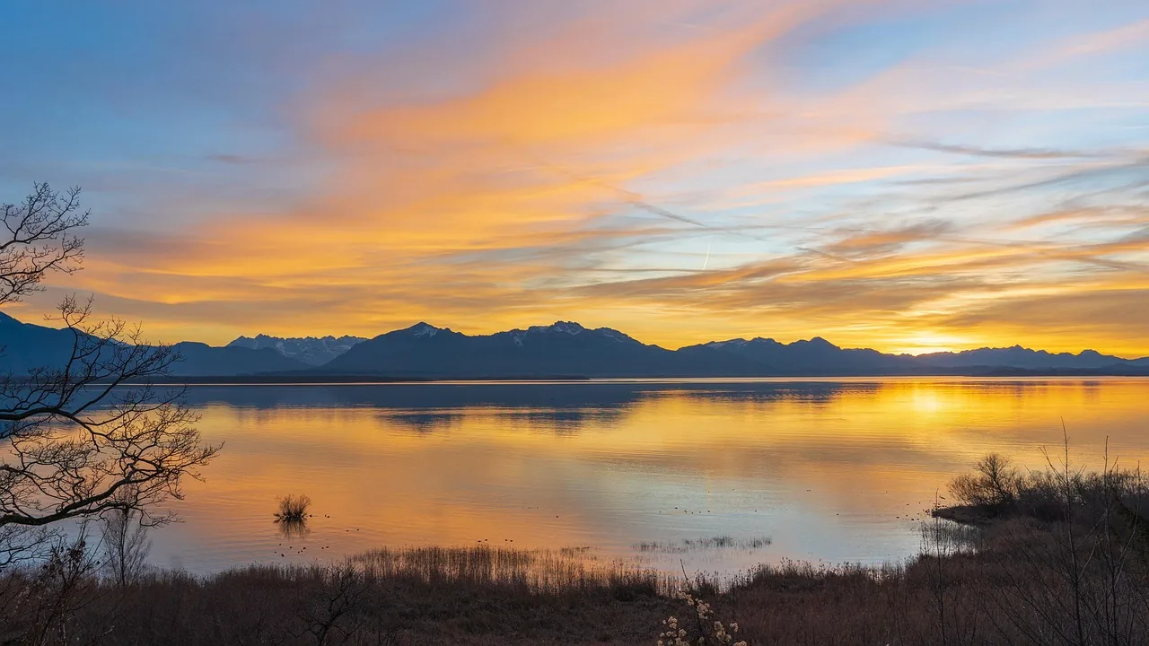 Warmes Morgenlicht ueber einem stillen See