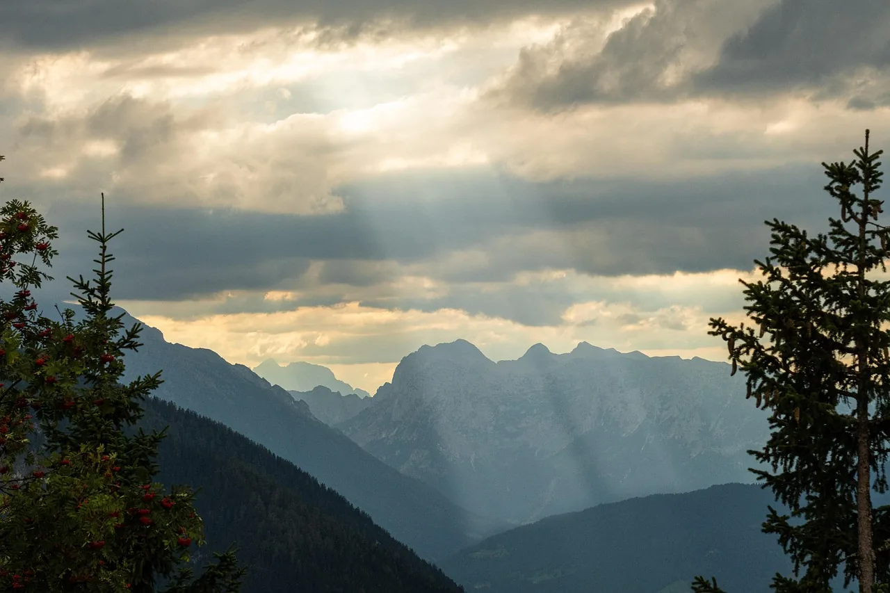 Des rayons de soleil percent les nuages au-dessus des montagnes